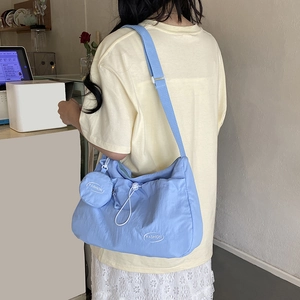 Light blue nylon crossbody bag with drawstring design and a mini coin purse attachment
