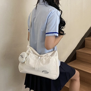 White canvas messenger bag with drawstring and matching round coin purse pendant