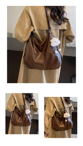 Detail of deep brown PU leather tote bag with embossed logo and cloud charm