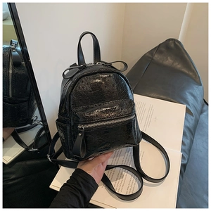 Detailed view of black mini backpack with glossy cracked texture and adjustable straps