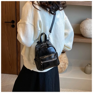 Detailed back view of a black mini backpack with glossy wrinkled PU leather texture