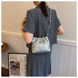 Close-up of silver Intrecciato woven bucket bag with elegant metallic chain strap detail