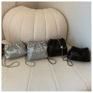 Detail of woven bucket bags in black and silver colors with elegant chain straps