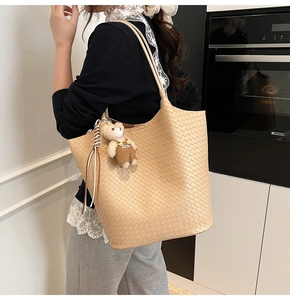 Nahaufnahme der großen geflochtenen Tragetasche in Beige mit Plüschbär und Lederfransen