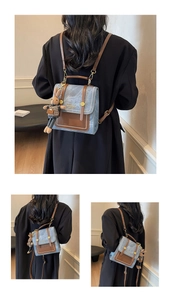 Detail view of mini denim backpack with brown leather trim and cute rabbit pendant