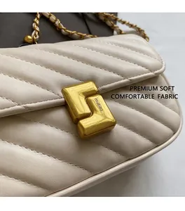 Detailed close-up of beige leather V-quilted texture and golden geometric metal lock