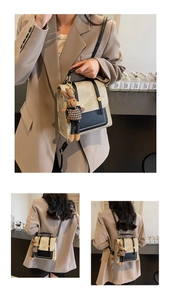 Detail of vintage cream crossbody bag with black trim and cute rabbit doll charm