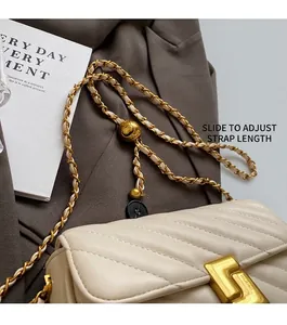 Detail showing the adjustable gold metal ball buckle on a cream quilted chain bag strap