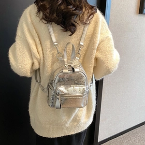 Mini silver metallic backpack for women with textured PU leather on a model's back