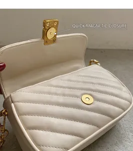 Detail of cream quilted leather bag featuring a gold magnetic snap closure design