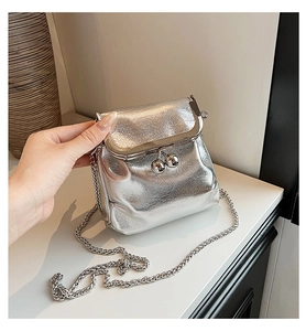 Gros plan du mini sac seau argenté métallisé avec texture plissée et chaîne argentée