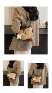 Détail du sac seau vintage avec bordures en cuir contrasté, fermoir et logo gravé