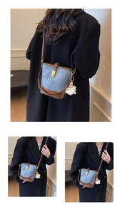Détail d'un sac seau en tissu marbré avec finitions en cuir marron et breloque en peluche