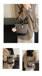 Détail du sac seau bicolore avec fermoir doré et pendentif monstre en peluche