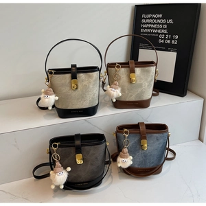 Detail of four vintage bucket bags with marble texture, metal buckles and plush charms