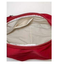 Detail view of red fabric shoulder bag showing interior lining and smooth plastic zipper