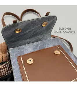 Detail view of the vintage canvas shoulder bag showing the secure dual magnetic buckles