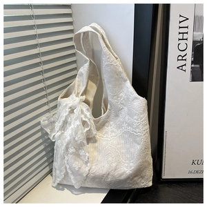 Detailed close-up of white floral lace tote bag featuring a large decorative bow