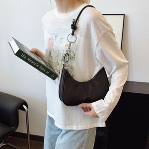 Borsa hobo a mezzaluna nera minimalista con tracolla ad anello d'argento sulla modella
