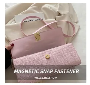 Pink crossbody bag featuring refined woven texture and gold magnetic buckle closure