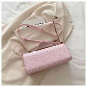 Close-up of pink woven leather texture on rectangular handbag with matching shoulder strap