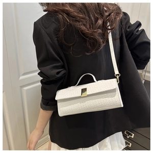 White woven leather bag with gold buckle shown on model in a stylish formal outfit