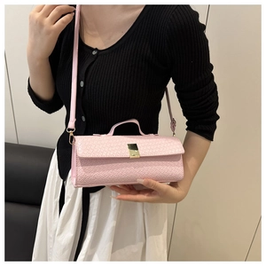Detail of pink woven leather evening bag with golden buckle and sleek carry handle