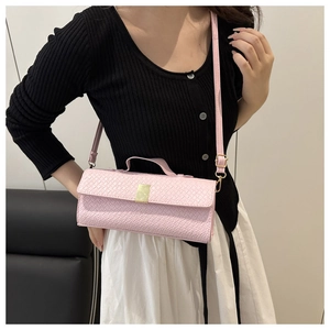 Detail of pink embossed crossbody bag showing gold metal clasp and textured surface finish