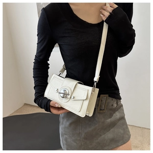 Detail of white rectangular crossbody bag featuring round metal twist lock and slim strap