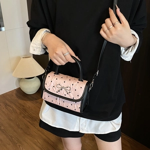 Pink heart print crossbody bag with silver bow accent and leather top handle