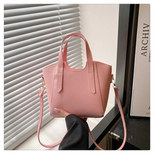 Detailed macro of pink lychee textured leather bag with gold metal hardware and strap