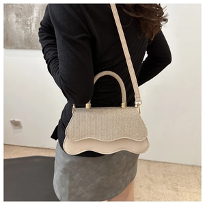 Close-up of sparkling rhinestone crossbody bag with a wave edge on a female model