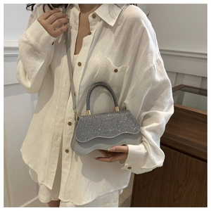 Détail du sac bandoulière argenté avec strass brillants et bordure ondulée unique