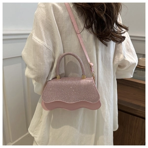 Dettaglio della borsa a tracolla con paillettes rosa con design a onde e finiture oro