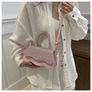 Borsa a tracolla rosa con paillettes e bordi ondulati indossata da modella