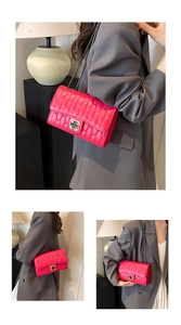 Detail of rose red quilted crossbody bag with flower-shaped gold metal lock and chain strap