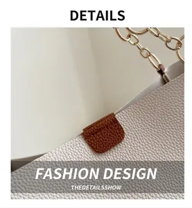 Detail of lychee pattern leather stitching with gold metal chain strap on tote bag