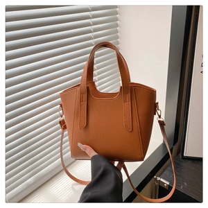 Detail of the brown lychee pattern leather texture on a chic bucket bag with gold hardware