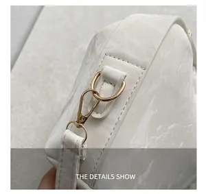Close-up of marble pattern PU leather handbag with light gold metal lobster clasp hardware