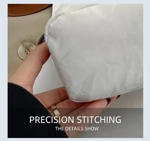 Detailed close-up of precise stitching on the white pleated PU leather handbag surface