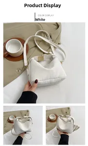 Detail shot of white textured cloud bag with metal buckle and adjustable shoulder strap