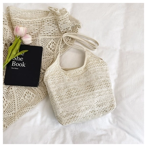 Detailed macro view of white lace floral crochet texture on a summer beach tote bag