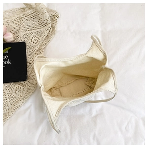 Detailed view of white canvas tote bag with floral lace trim and spacious interior