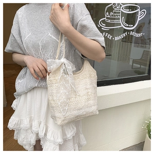 Detail of crochet lace tote bag featuring intricate floral patterns and a soft bow tie