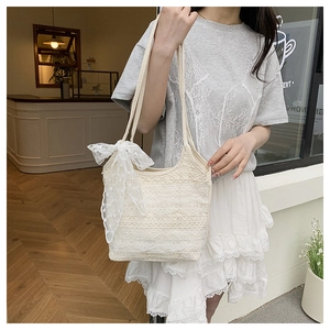 Close-up of elegant cream lace tote bag featuring intricate crochet and bow detail