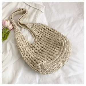 Detail of cream-colored handmade woven tote bag with intricate crochet hollow mesh pattern