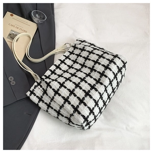Detailed view of the black and white checkered tweed tote bag with leather straps
