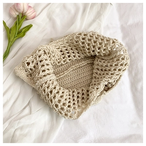 Detail of handmade cream floral woven tote bag with hollow diamond pattern on white cloth