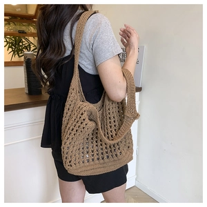 Close-up of brown hollow crochet knit bag showing detailed floral weaving and texture