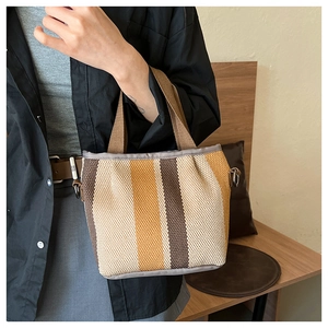 Détail d'un sac cabas rétro en toile rayée avec anses tressées et anneau en métal
